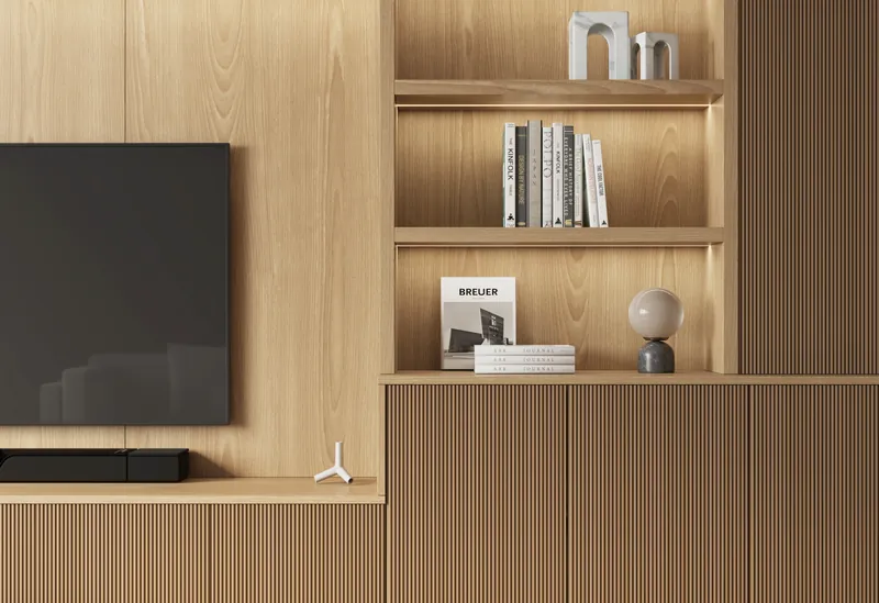 Detail of oak fluted base cabinets below a wall-mounted TV with lit shelving